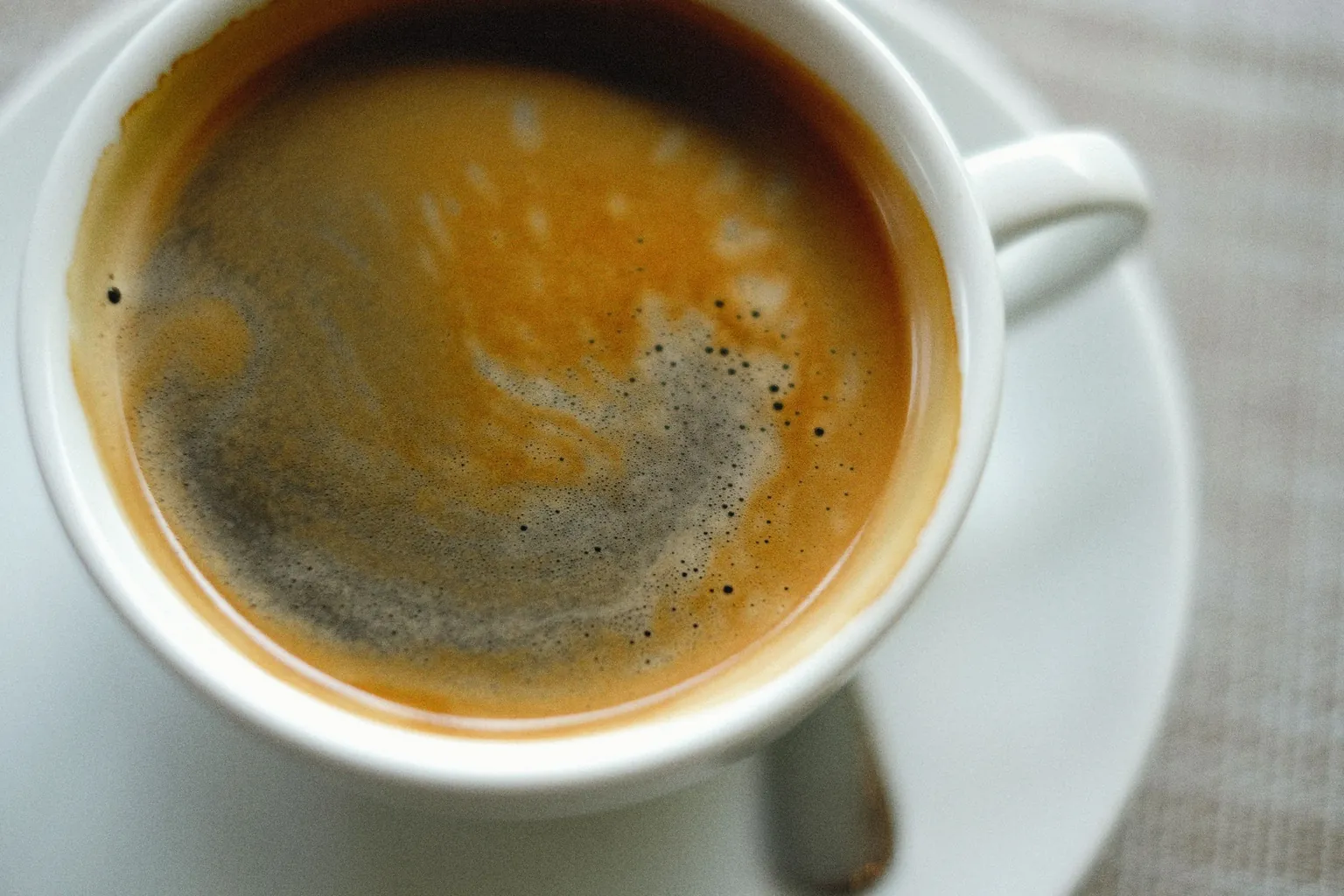 Tasse de café noir vue de dessus sur sa soucoupe